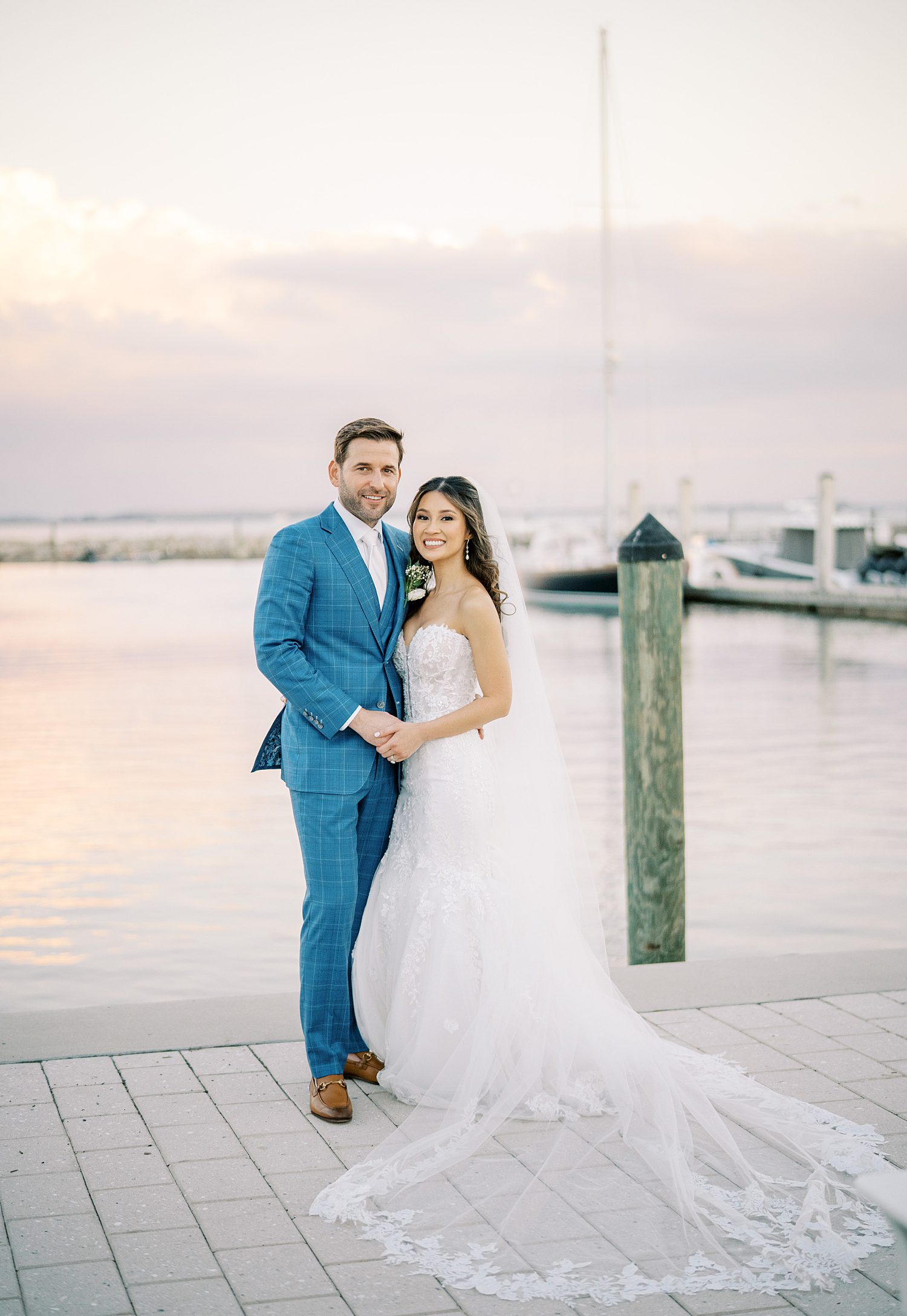 bride and groom hug on dock outside Tampa Yacht Club