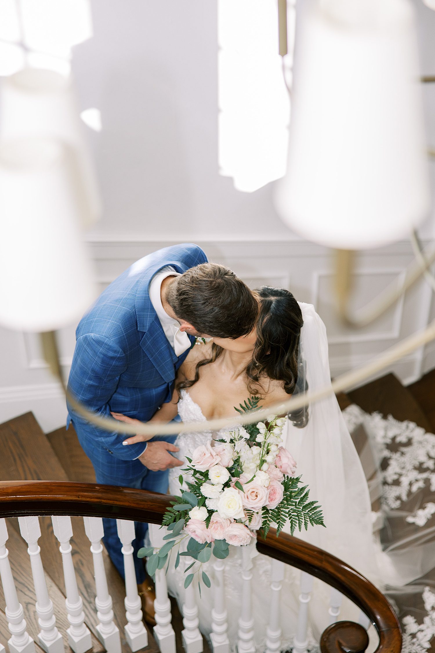 bride and groom kiss on staircase inside Tampa Yacht Club