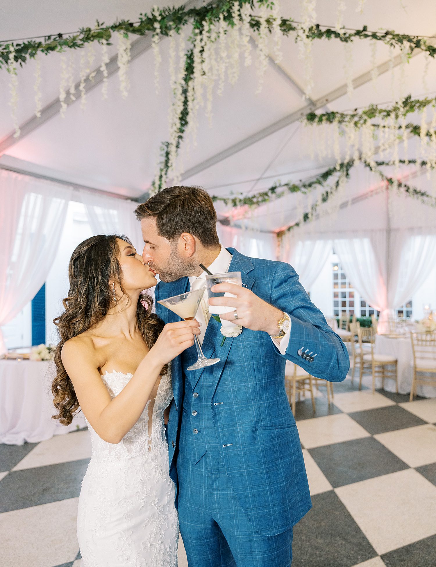 bride and groom kiss toasting champagne inside tent at Tampa Yacht Club