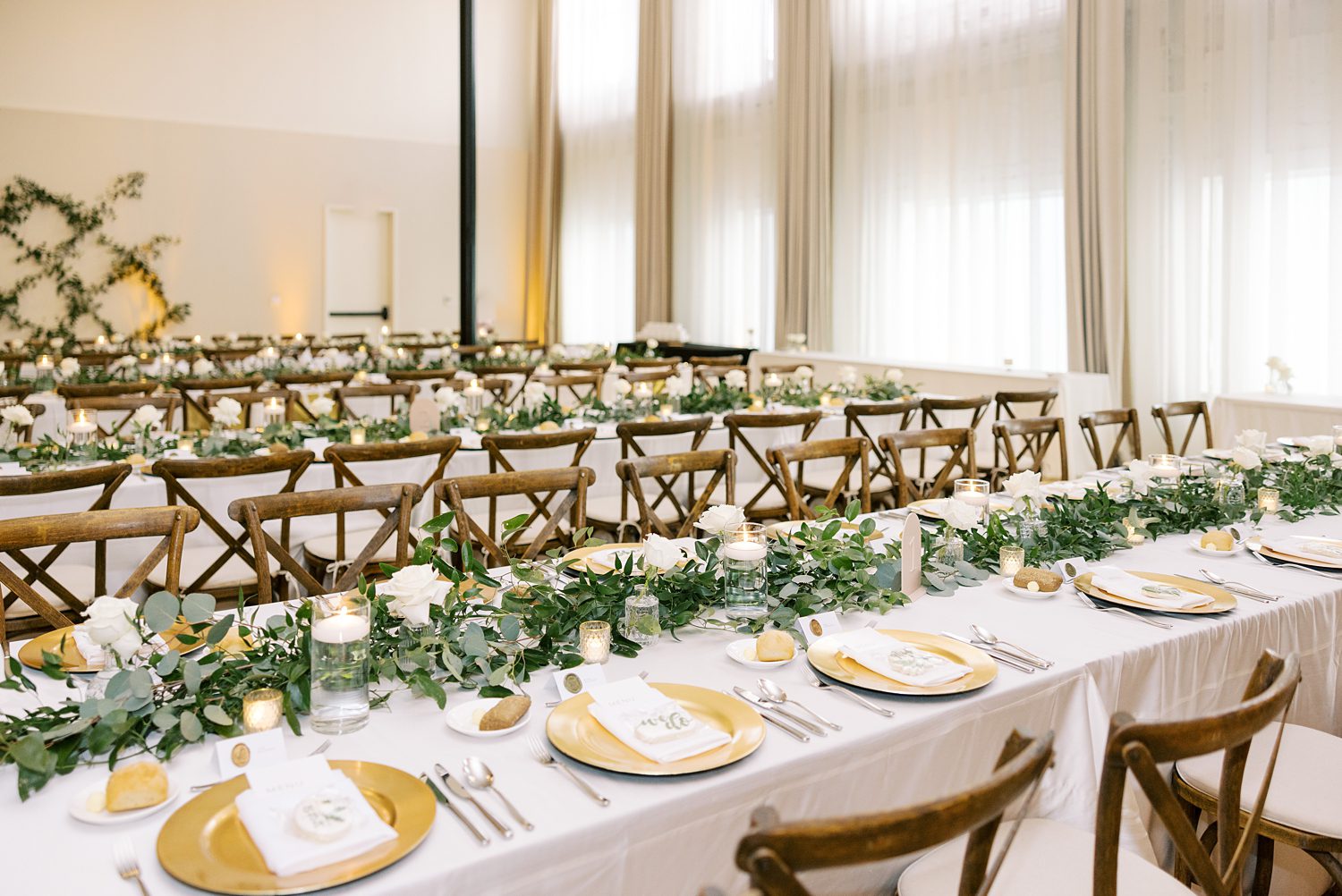 wedding reception at the Hotel Haya with gold plates, white roses, and greenery 
