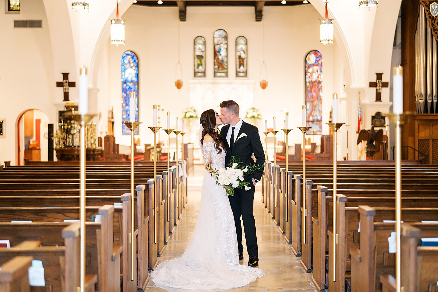 bride and groom kiss in aisle of St. Andrews Episcopal Church in Tampa FL