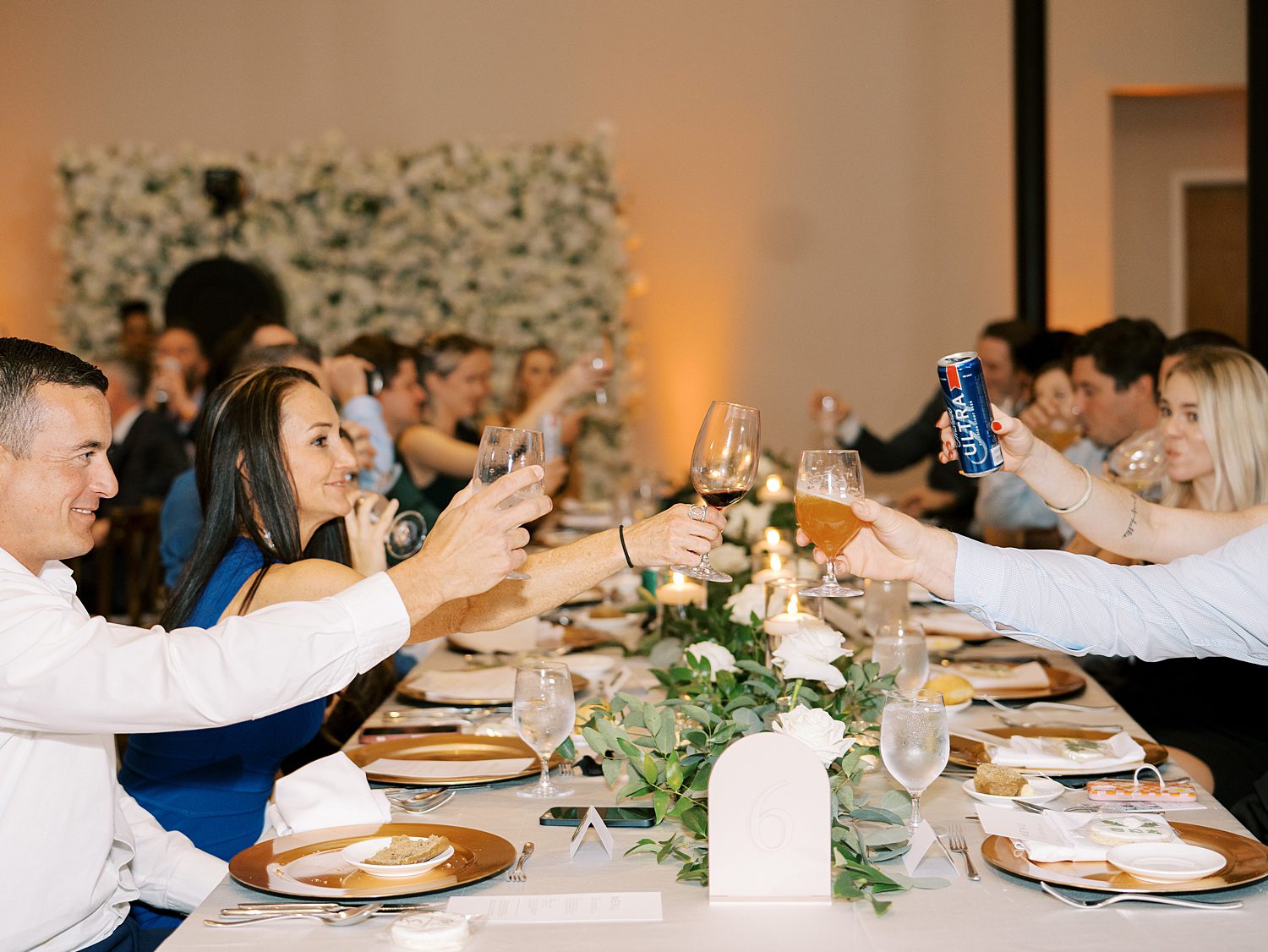 guests toast drinks across table during Tampa FL wedding reception 