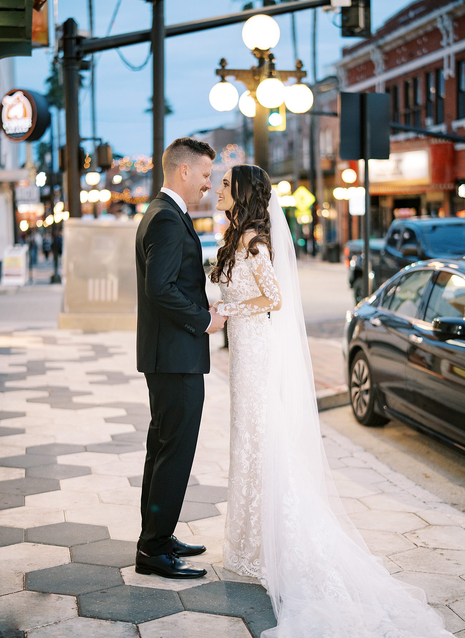 bride and groom kiss at night on Tampa sidewalk 