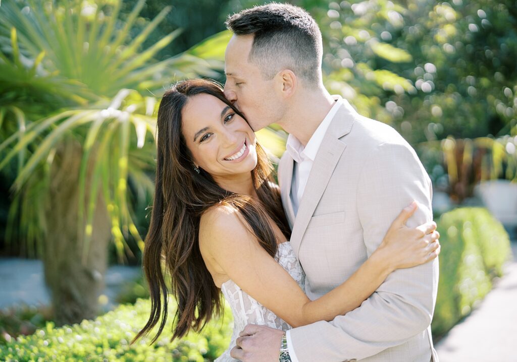 man kisses woman's forehead making her laugh during Hollis Gardens wedding portraits 