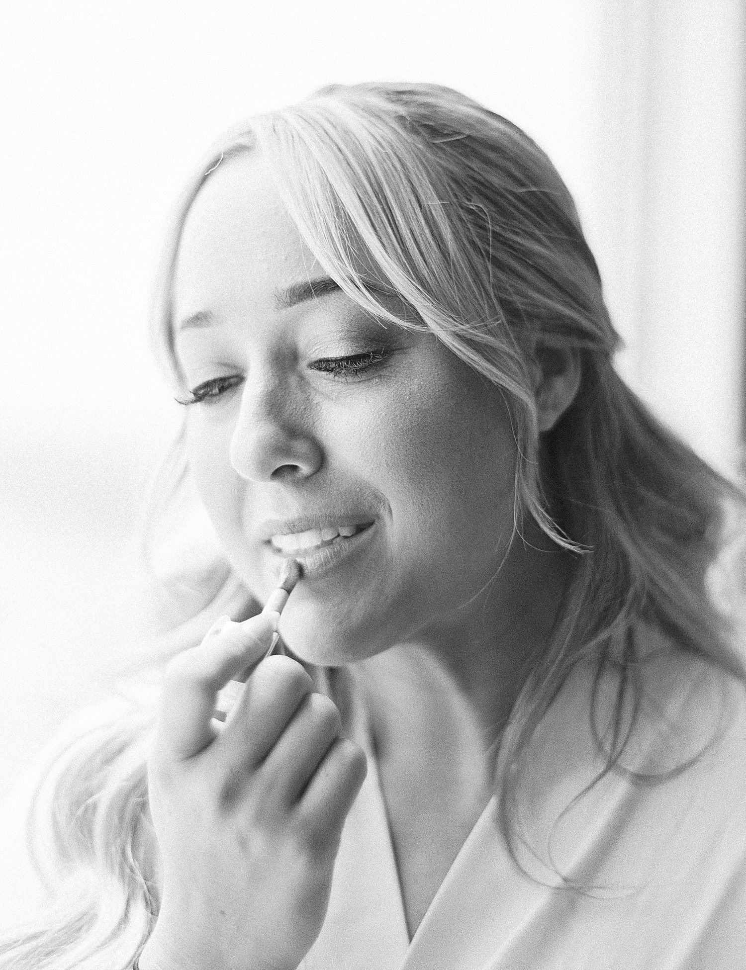 bride puts on lipgloss while preparing for Tampa wedding day