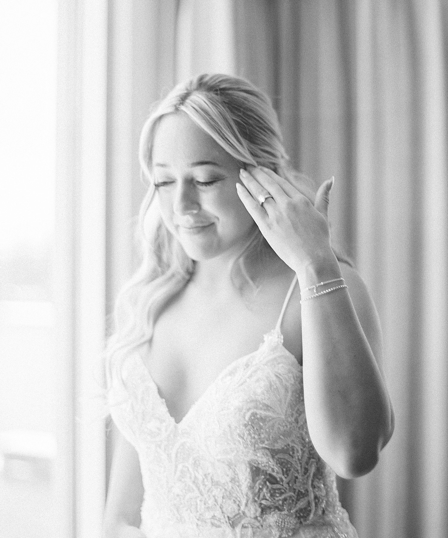 bride pushes hair behind her ear in Tampa FL hotel during wedding day prep