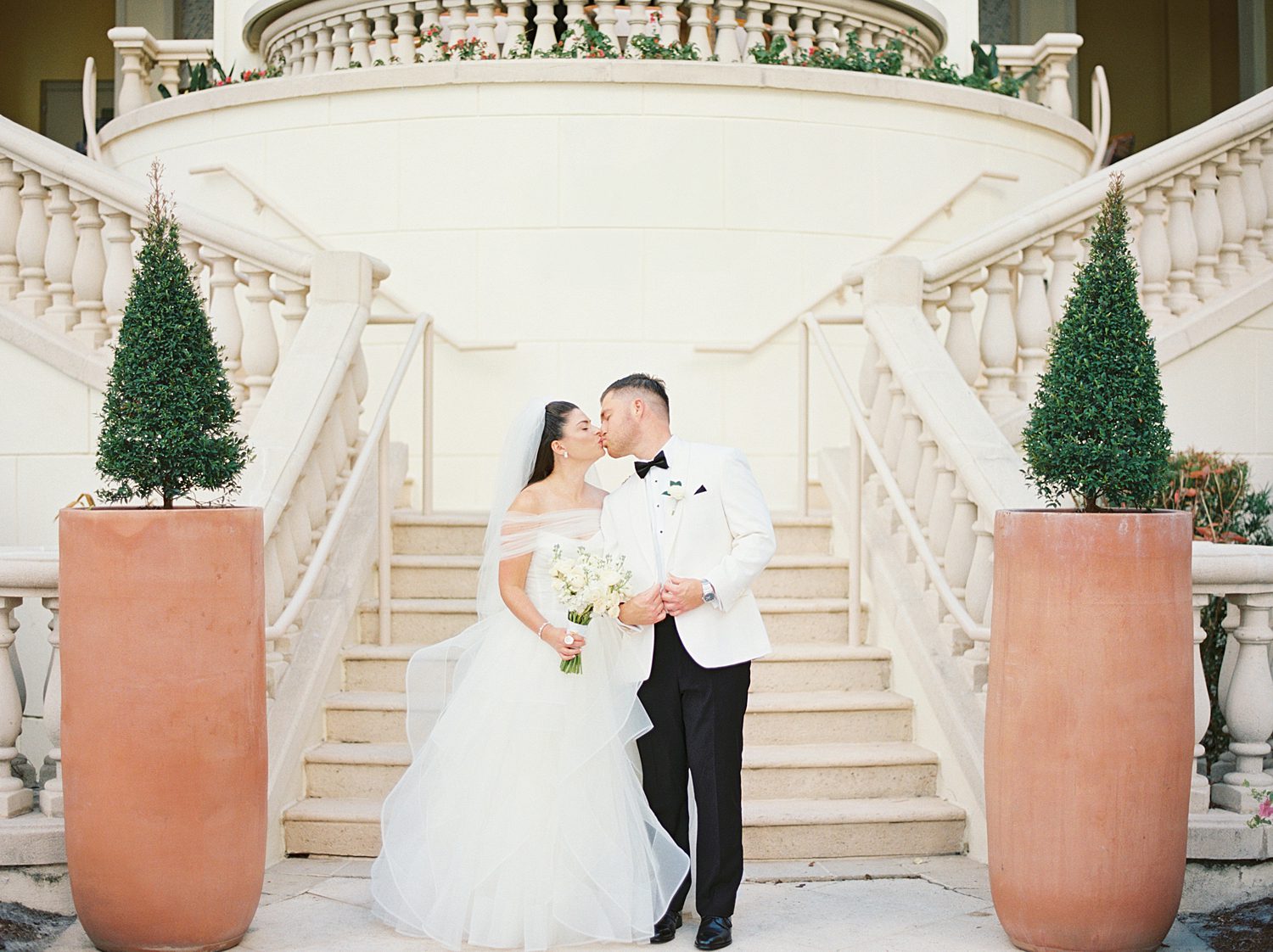 bride and groom hug in front of staircase at the Ritz Carlton Sarasota