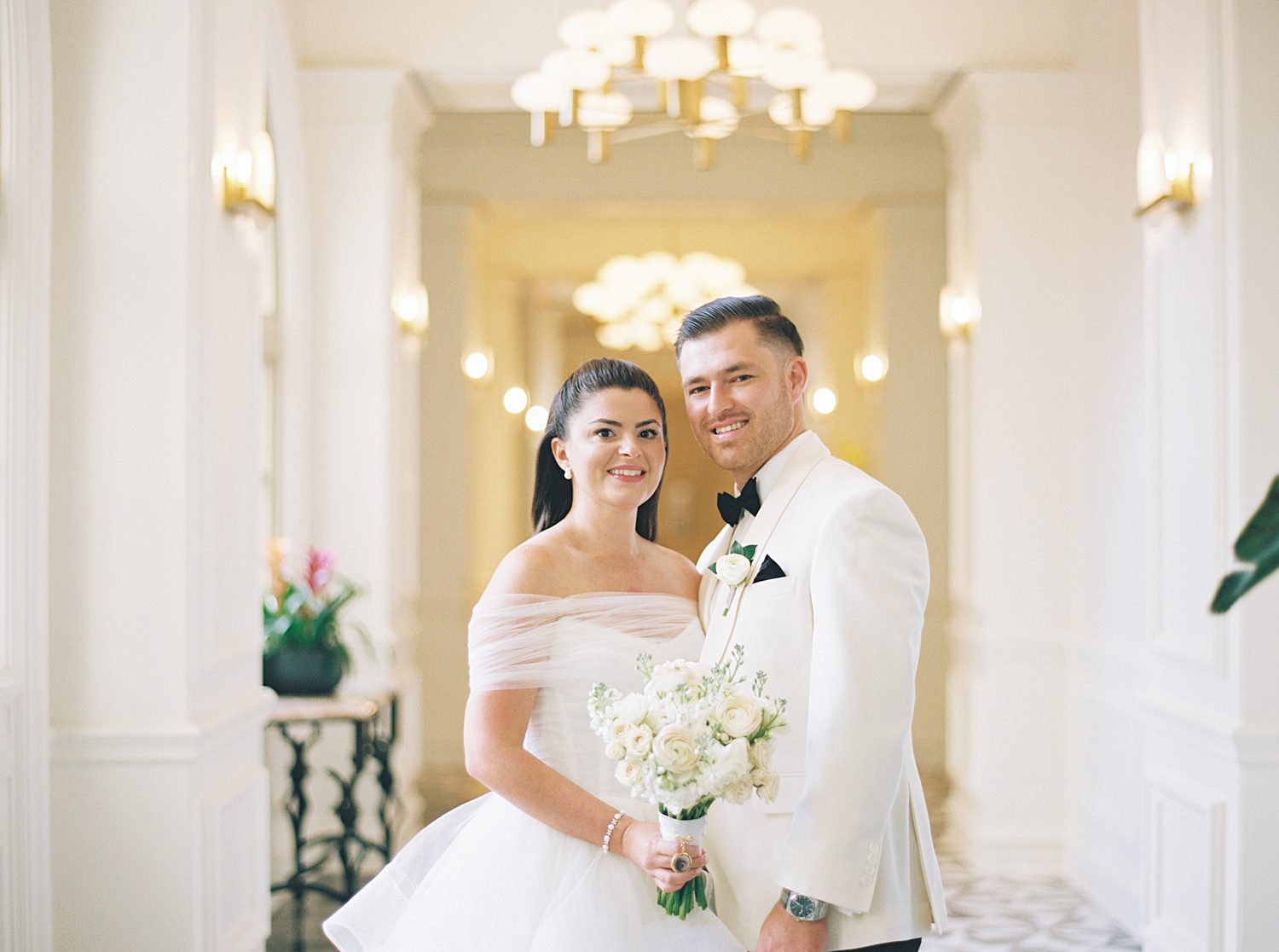 bride and groom stand together smiling on wedding day