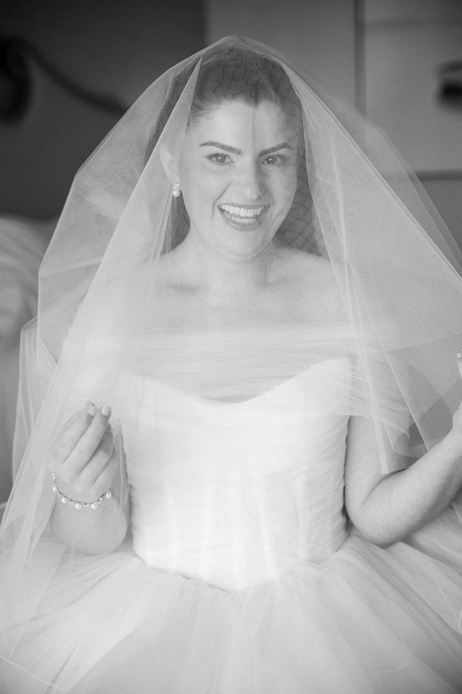 bride smiles under veil during prep at the Ritz Carlton Sarasota