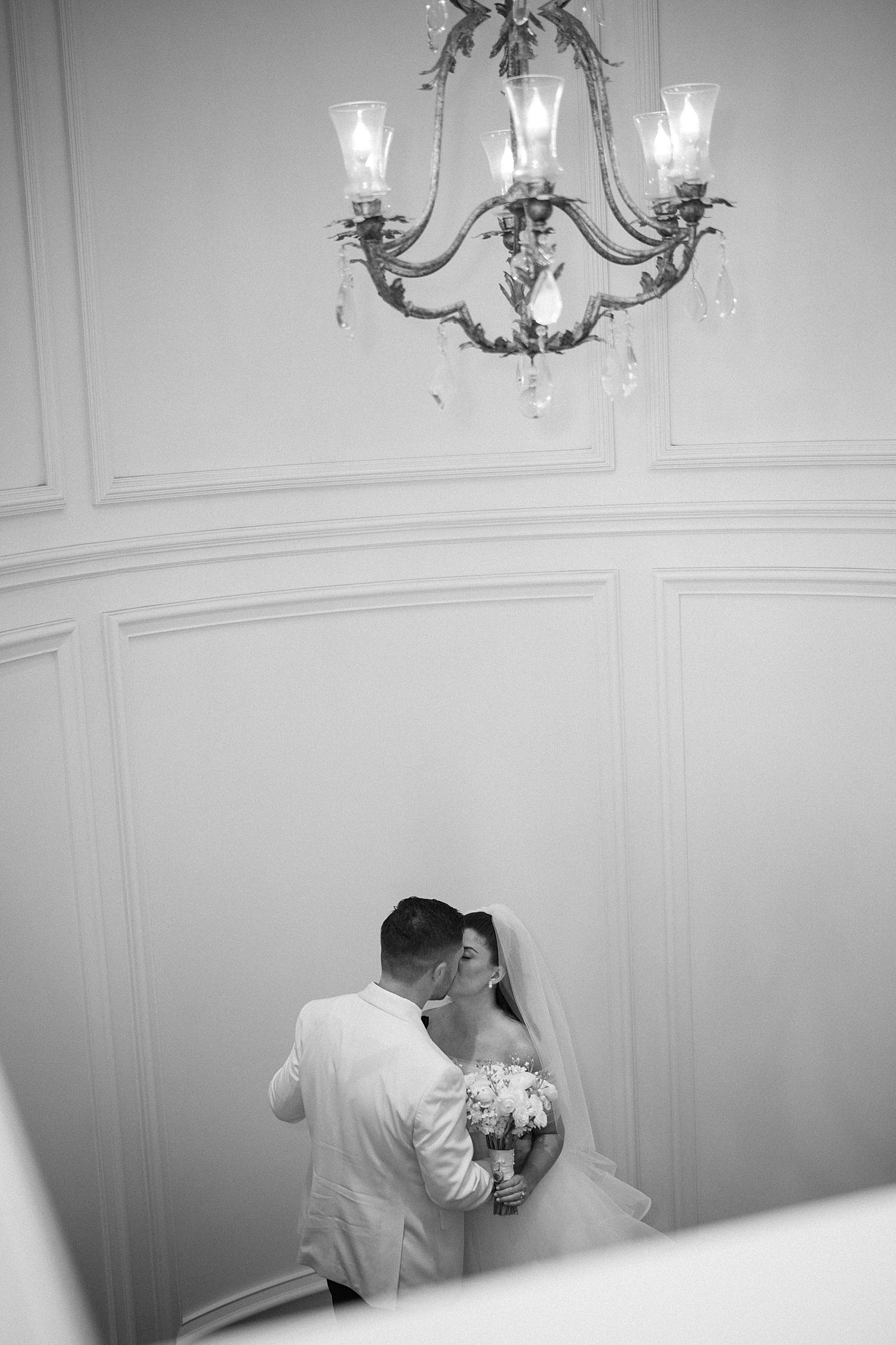 newlyweds kiss in staircase of the Ritz Carlton Sarasota