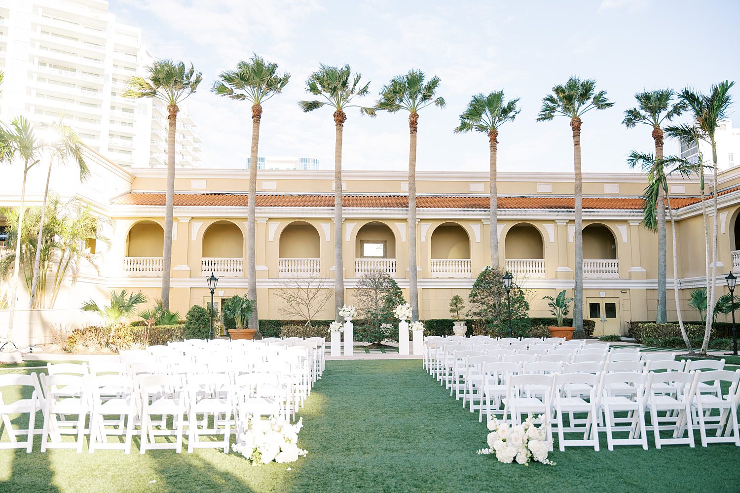 wedding ceremony site on lawn at the Ritz Carlton Sarasota with white chairs and flowers