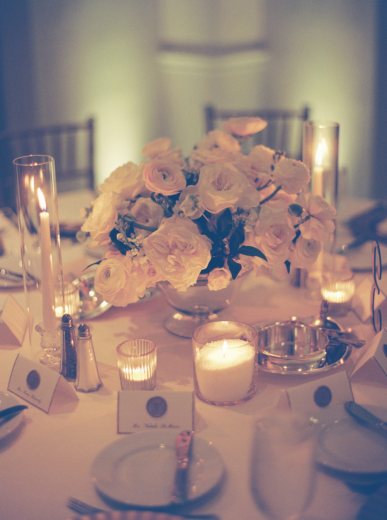 wedding reception with candle light tables and white bouquet in center