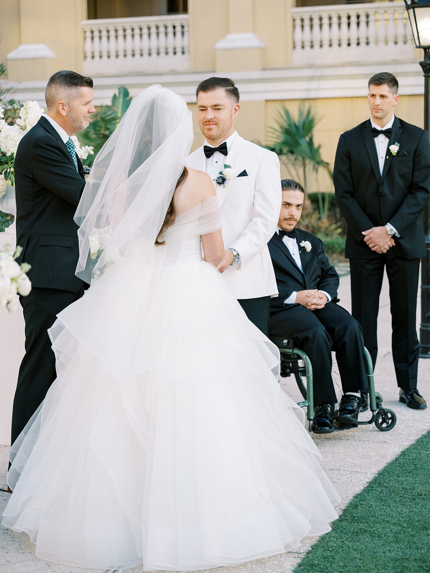 bride and groom smile during wedding ceremony on lawn at the Ritz Carlton Sarasota