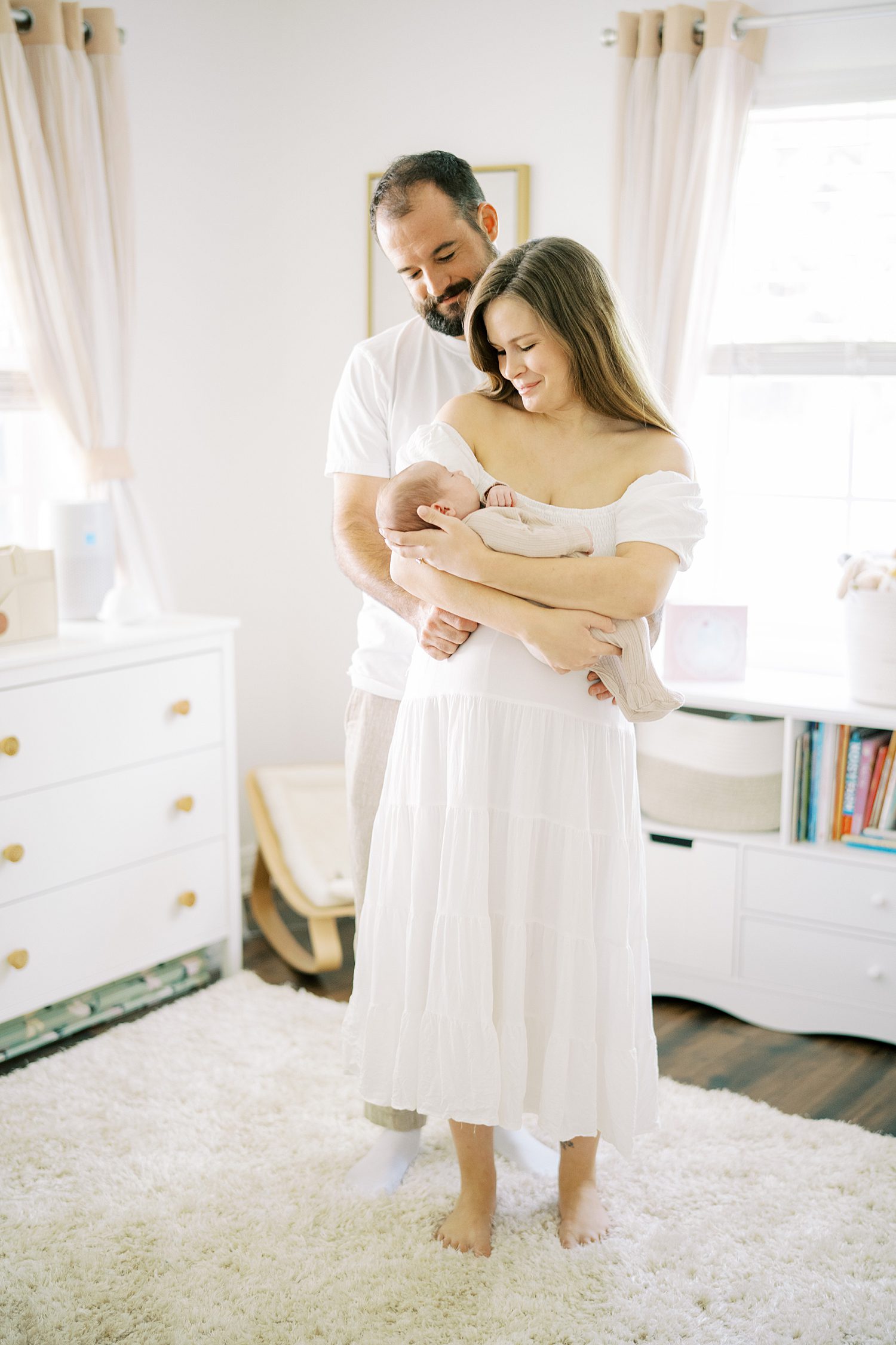Tampa family photographer captures parents snuggling newborn daughter during newborn lifestyle photo session