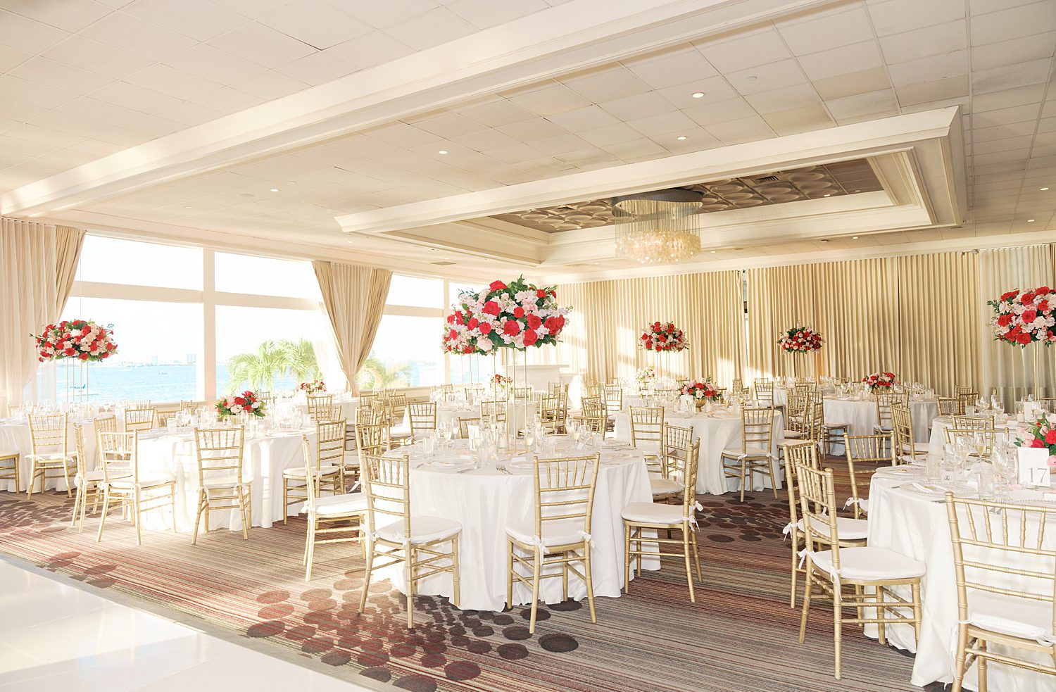 reception at the Rusty Pelican Miami with gold chairs and bright pink flowers 