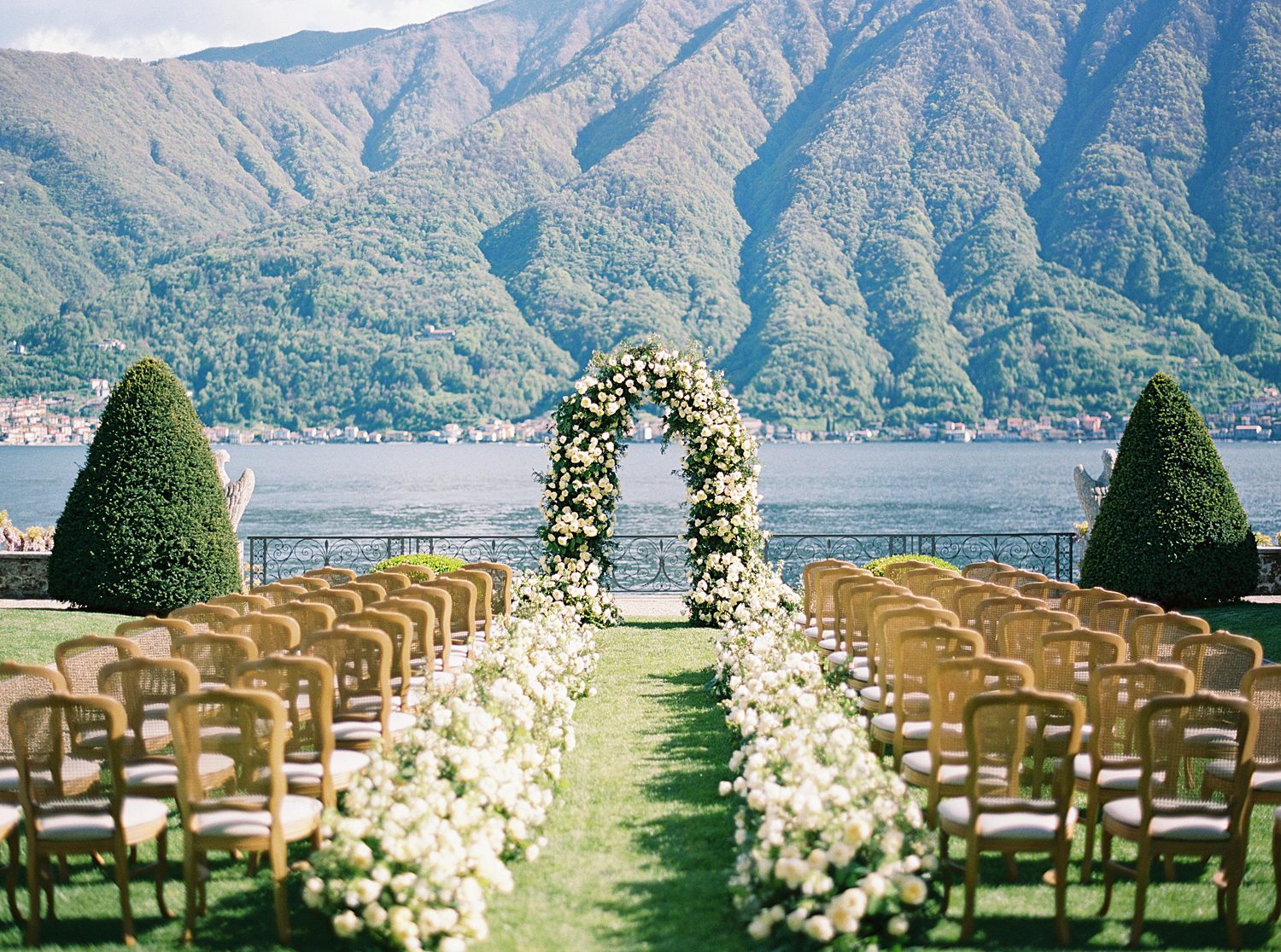 ceremony site with lake behind floral arbor in Italy