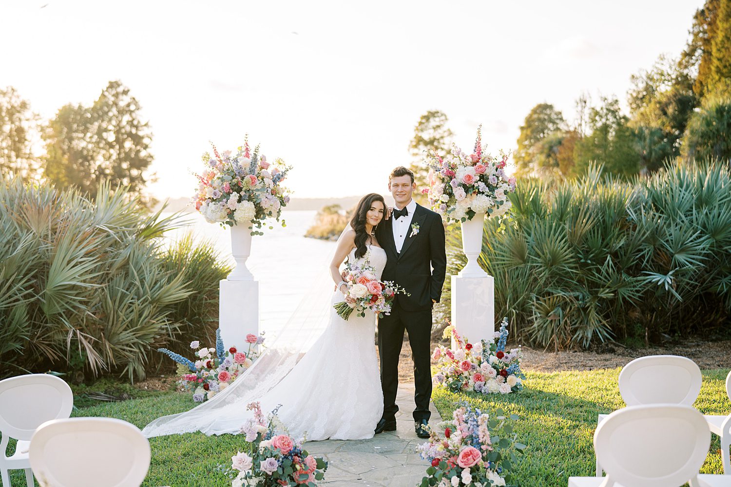 newlyweds stand at end of aisle at Stonelake Ranch