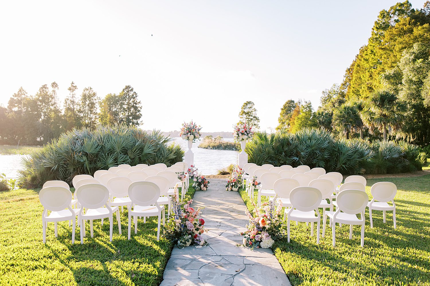 ceremony site by lake with white chairs at Stonelake Ranch
