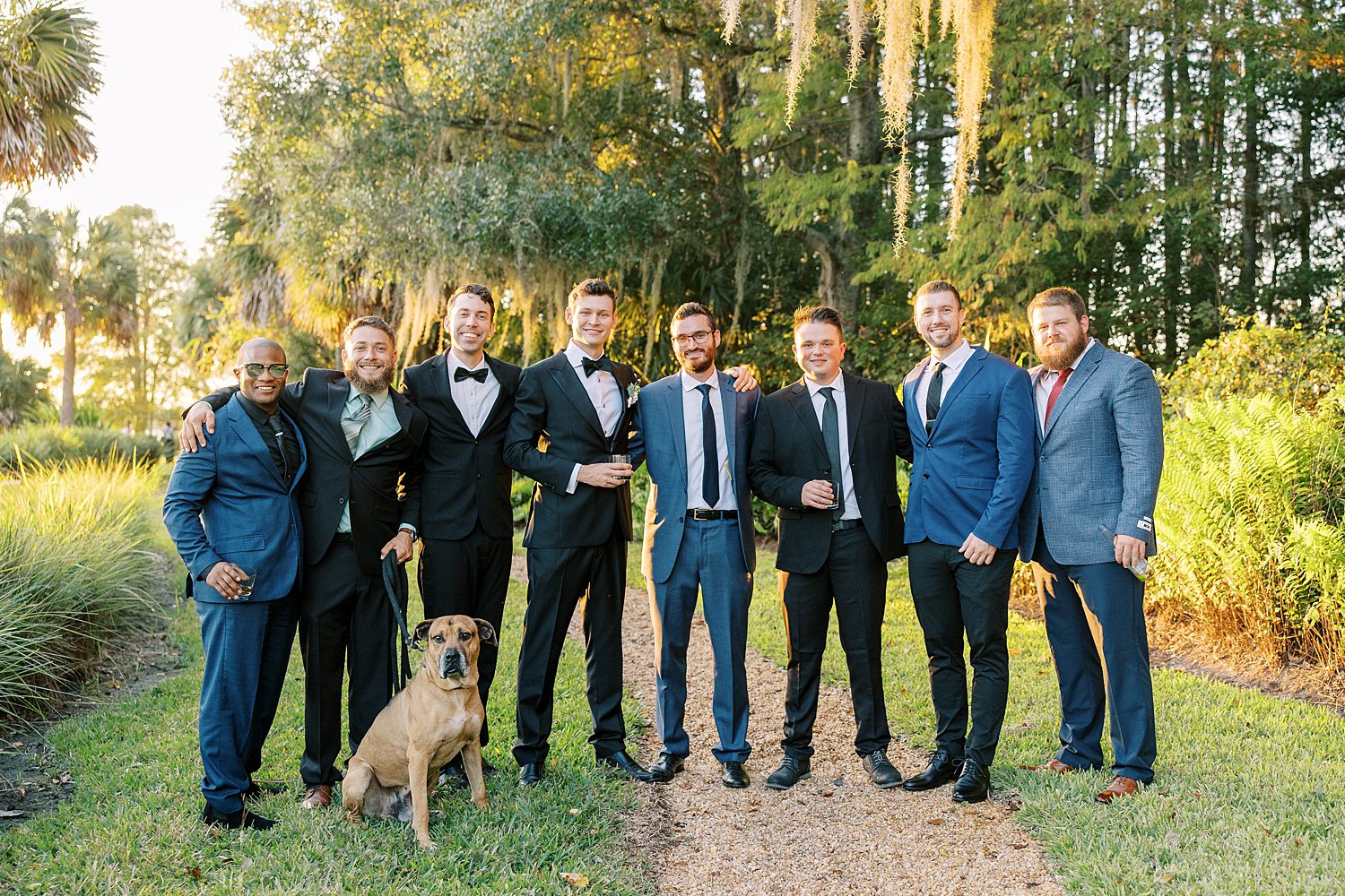 groom poses with groomsmen in black and blue suits