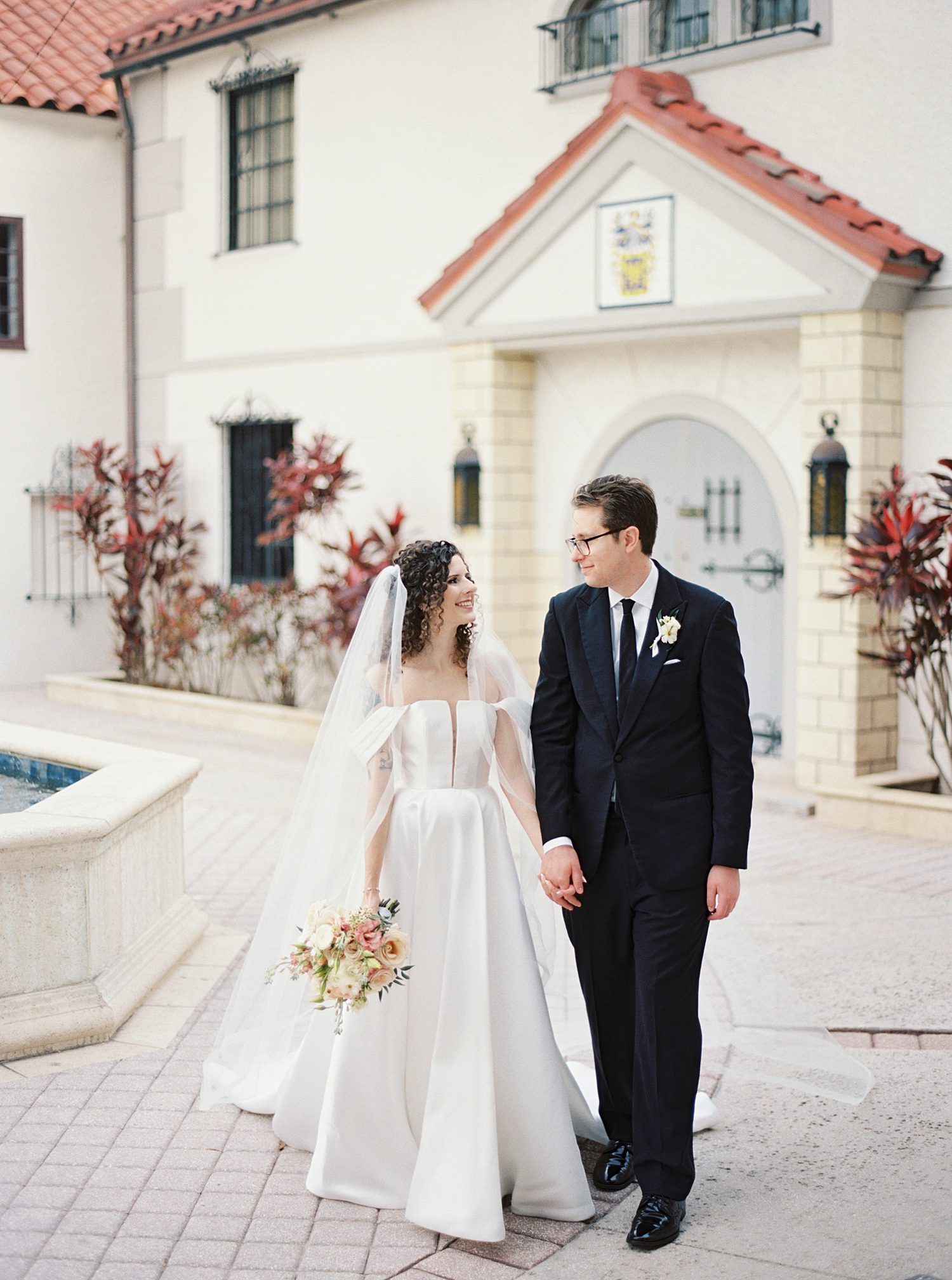 bride and groom hold hands walking through courtyard at the Bishop Museum of Science and Nature