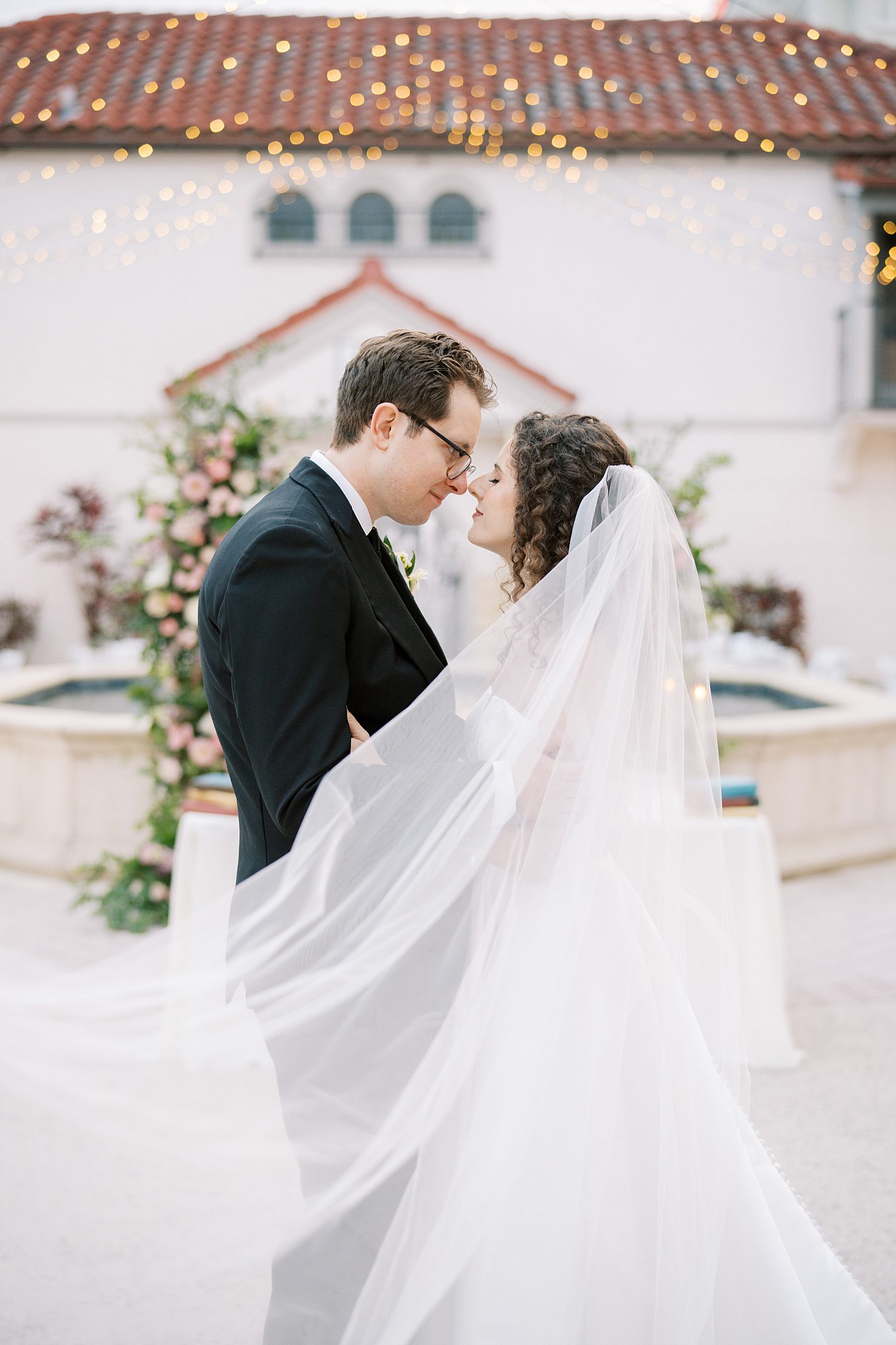 bride and groom stand in front of fountain in courtyard of the Bishop Museum of Science and Nature