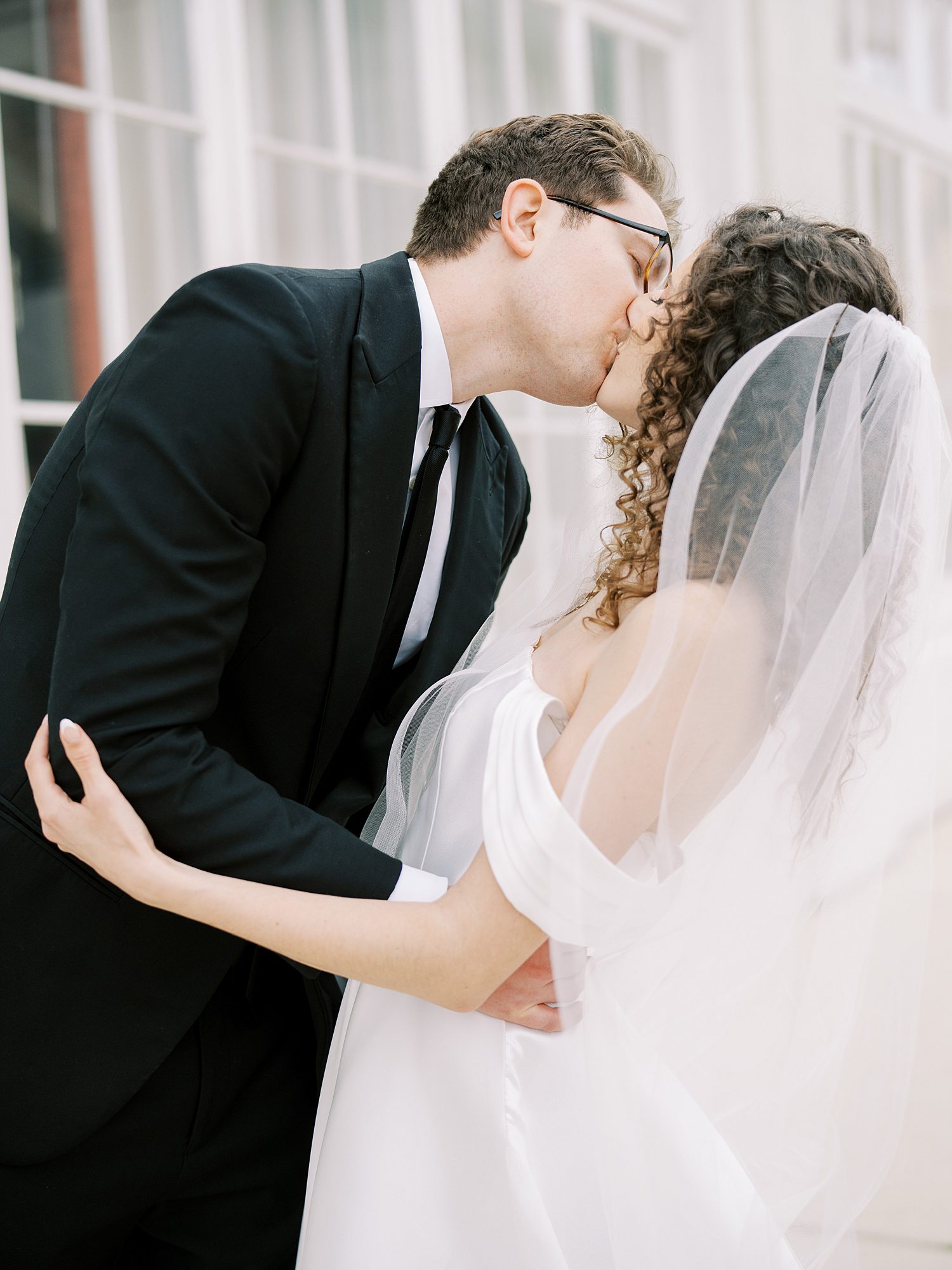 bride and groom kiss outside the Bishop Museum of Science and Nature