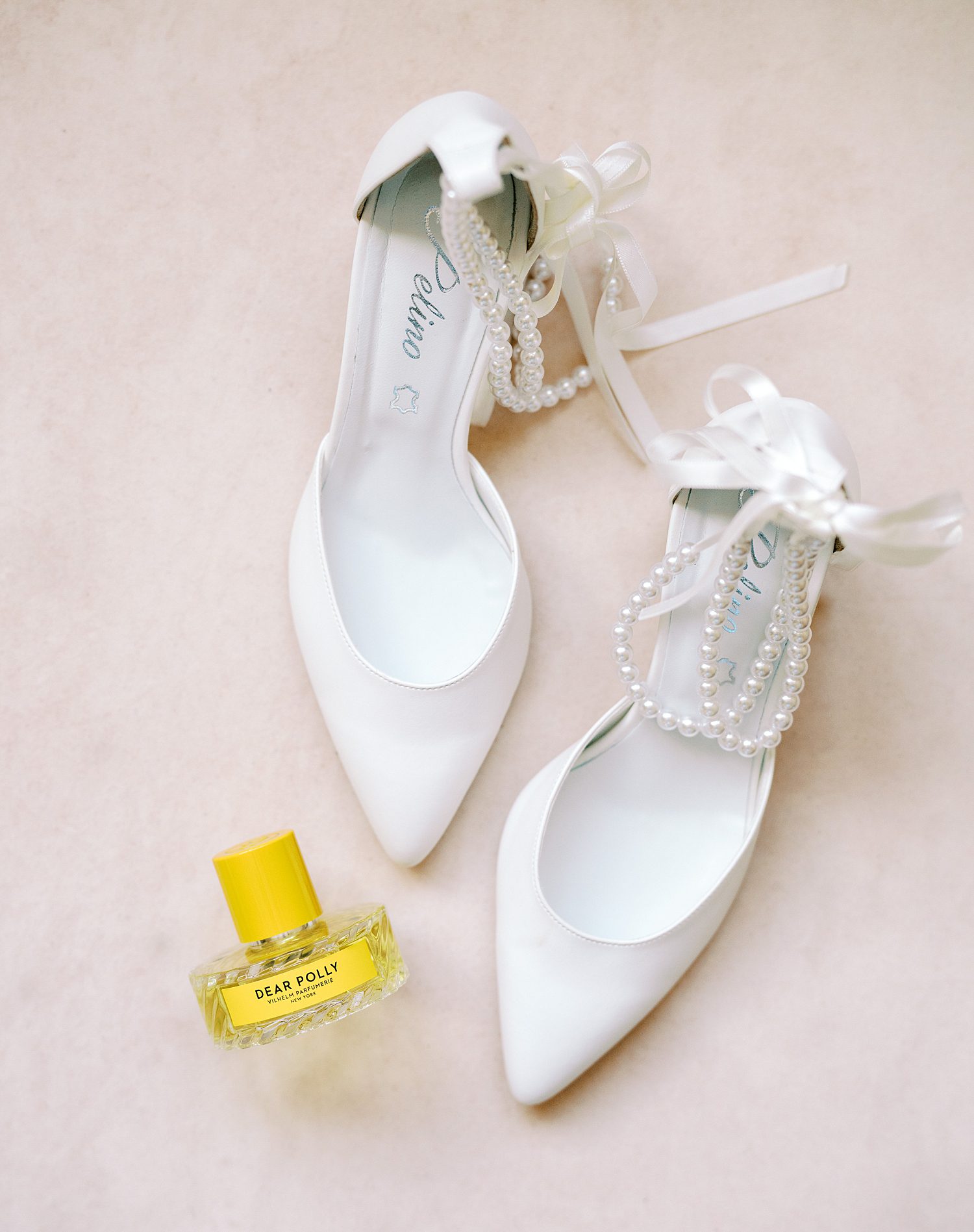 bride's white shoes with bows and pearl accents