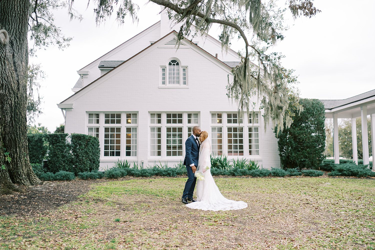 bride and groom kissing outside of Adams EState
