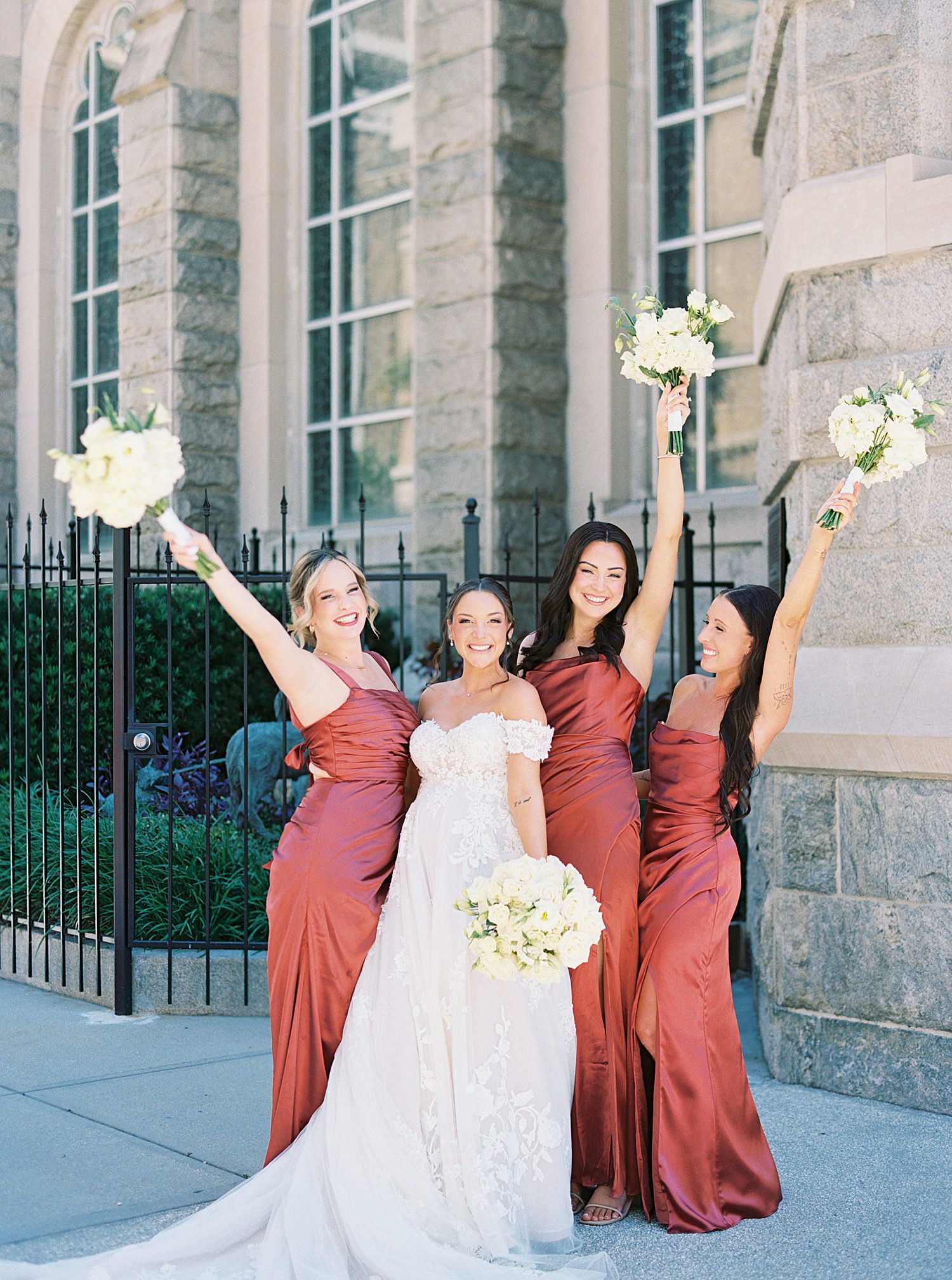 bride with bridesmaids in rust color dresses 