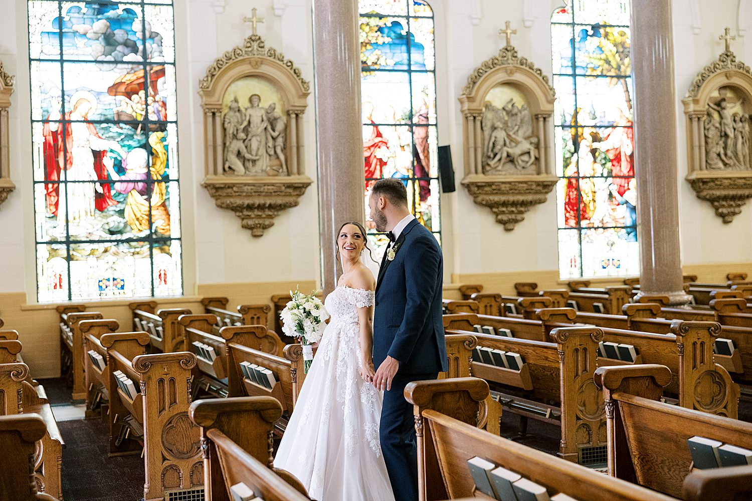 newlyweds walk down the aisle of Catholic church  