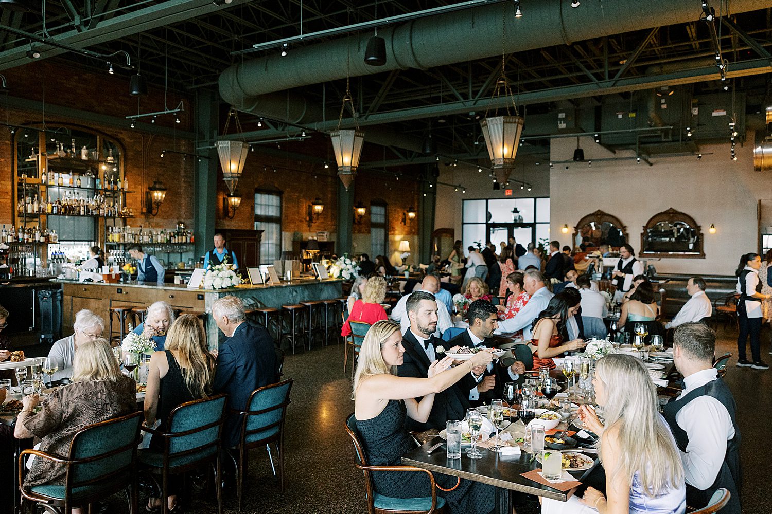 wedding guests raise their glasses in a toast to the newlyweds