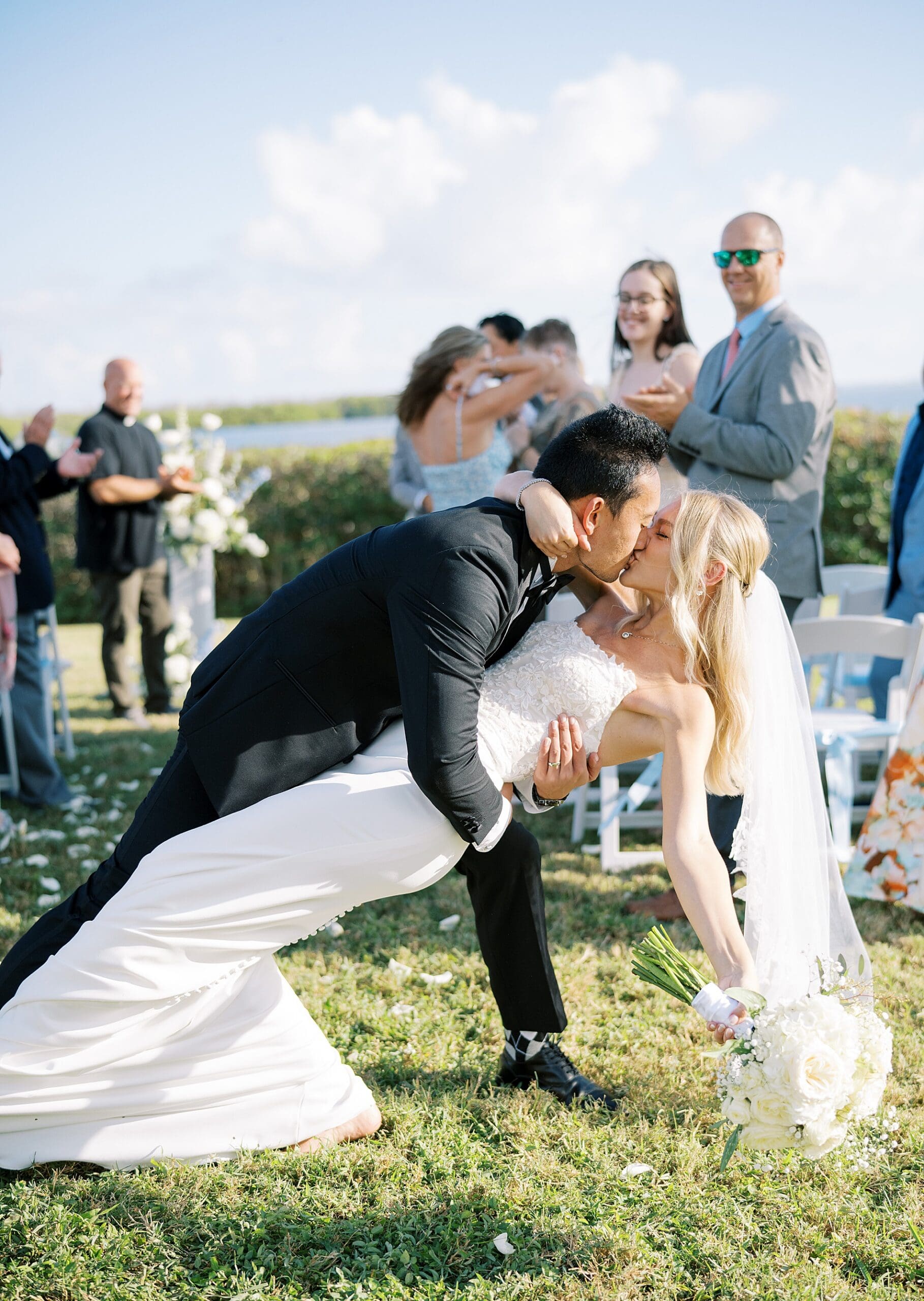 groom kisses bride as they exit wedding 