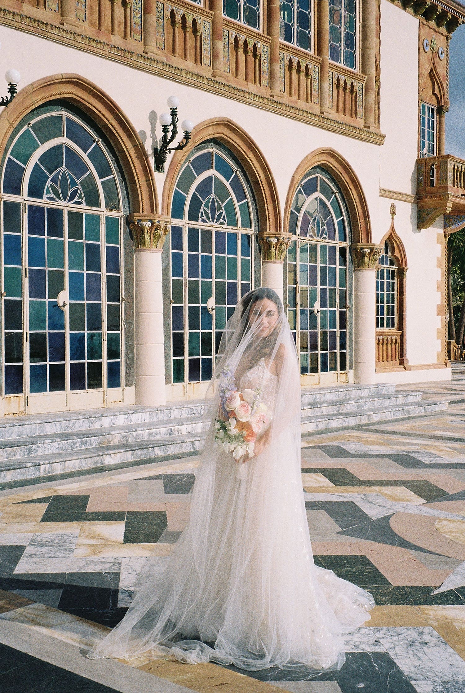 bridal portraits at The Ringling Museum in front of arched windows