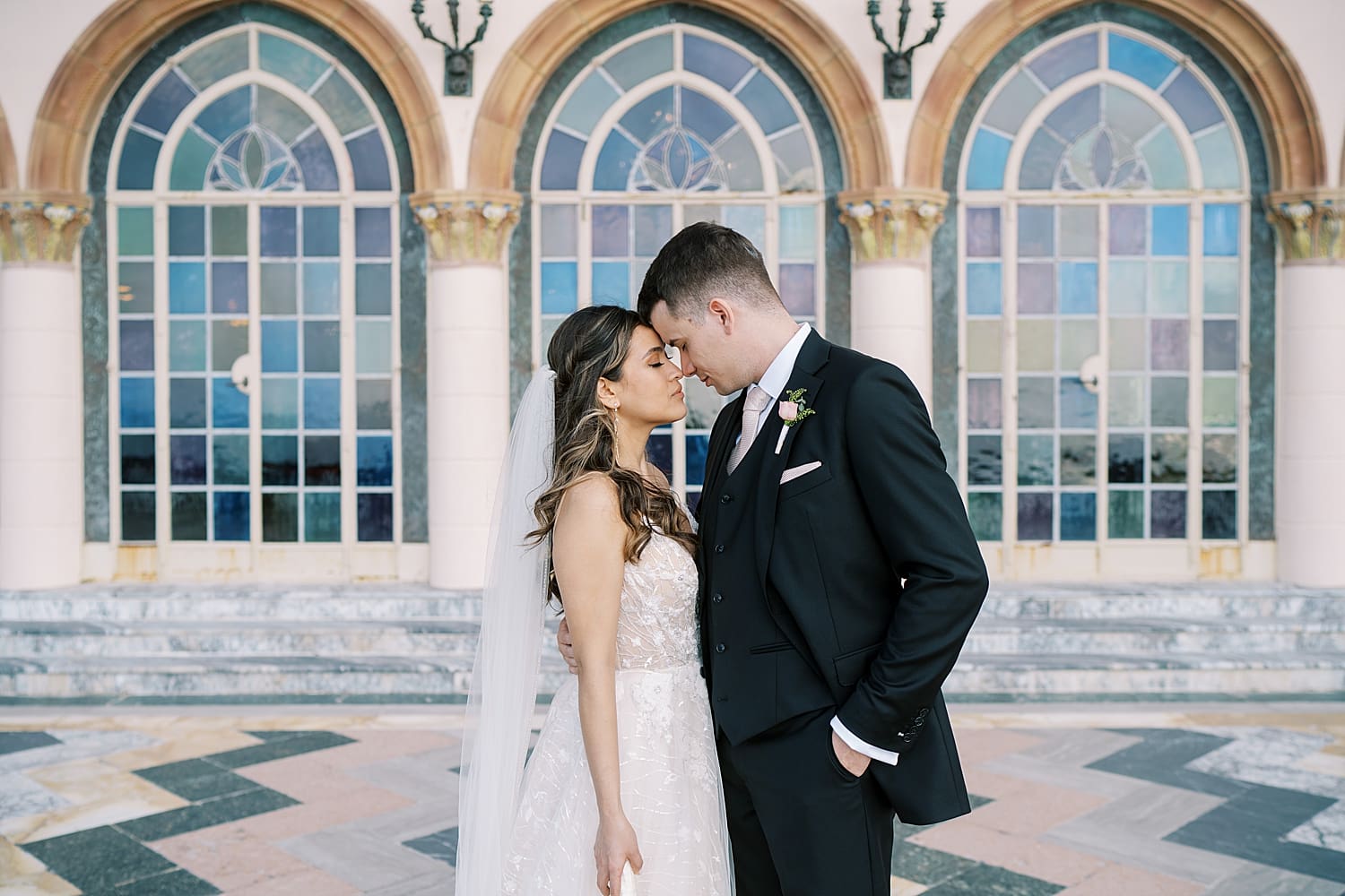 bride and groom outside of arched windows of The Ringling Museum