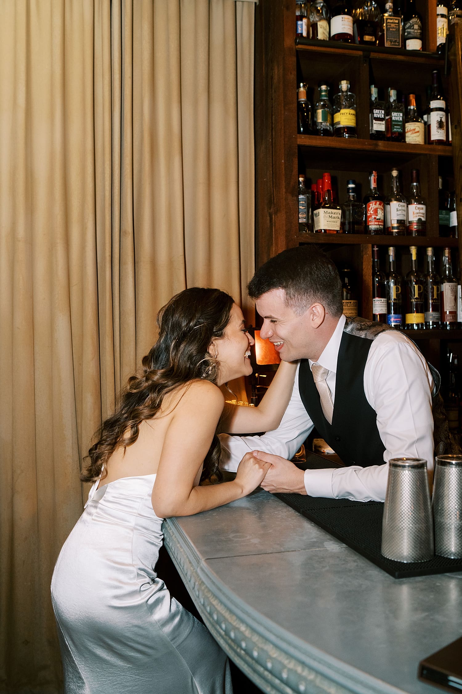 bride leans over bar to groom