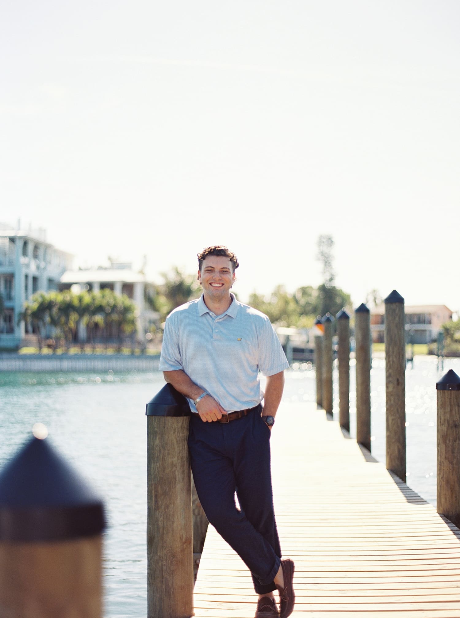man leans up against post on dock in Tampa, FL