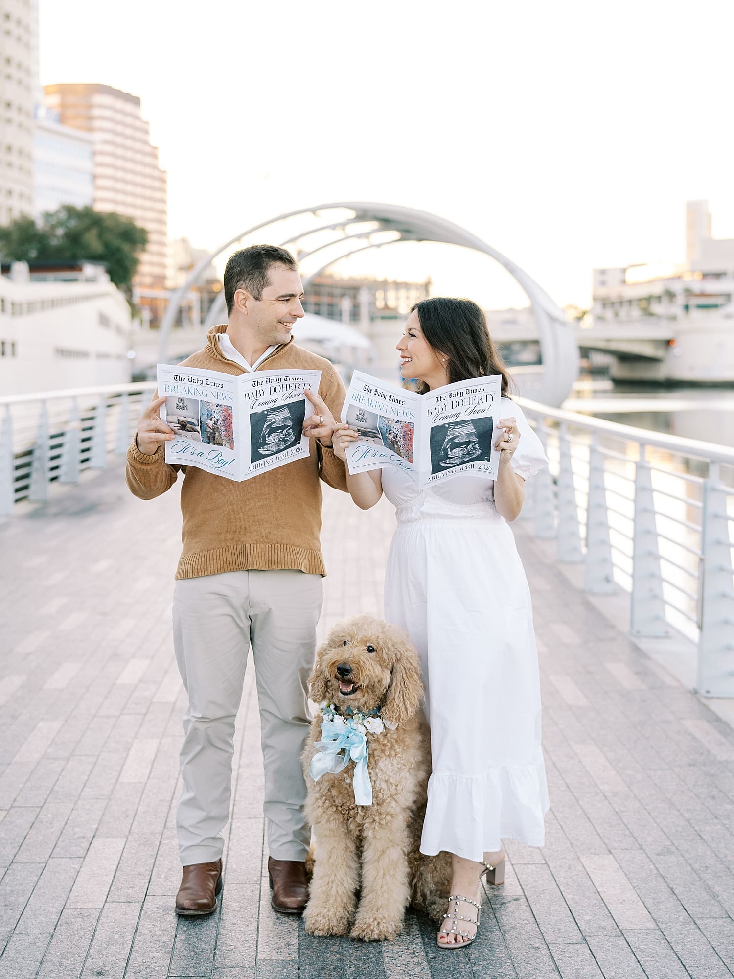 couple look at each other as they read personalized pregnancy announcement