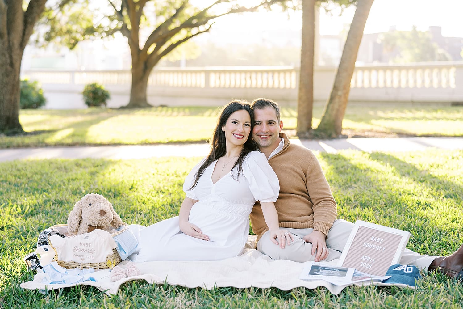 expectant parents during Tampa maternity session sitting on blanket and surrounded by meaningful items