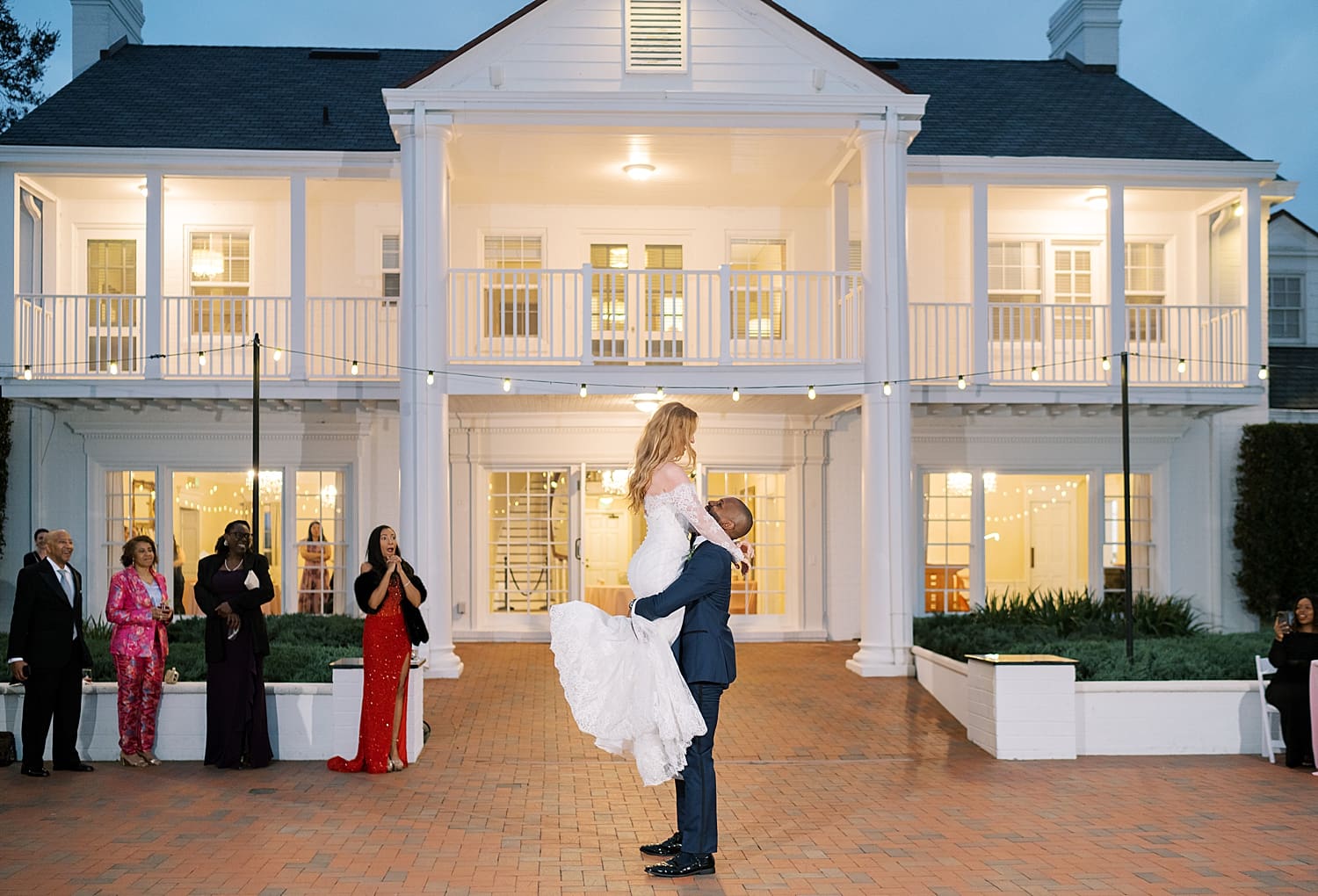 groom lifts bride up on the dance floor