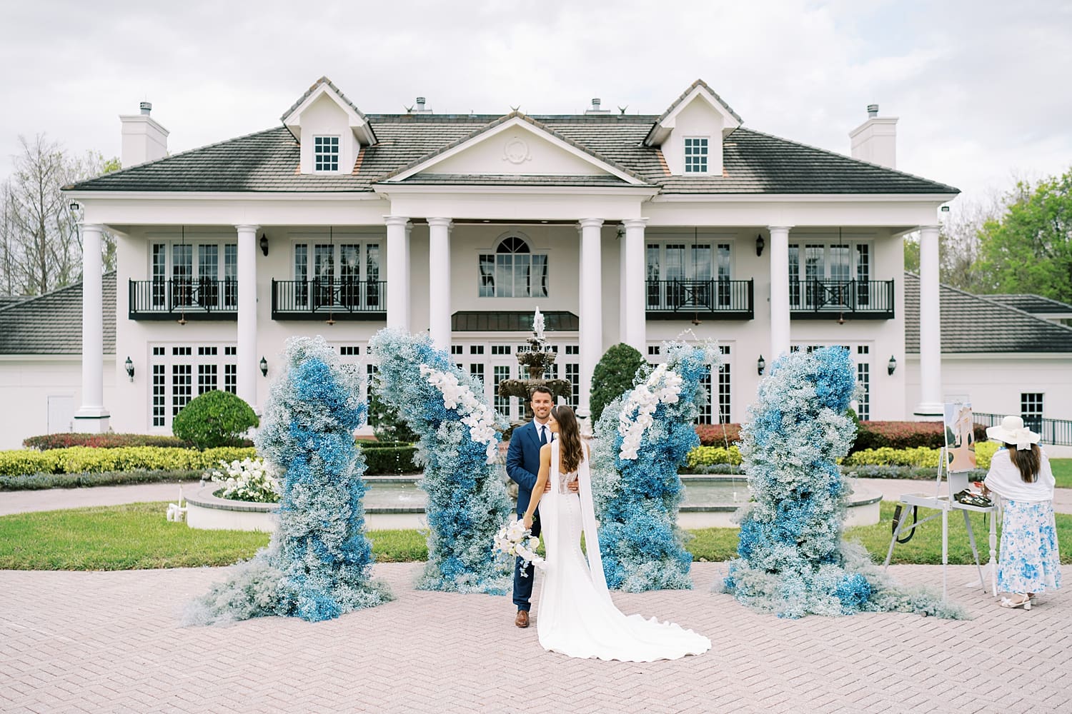 bride and groom portraits in front of Luxmore Grande Estate with blue and white floral installments