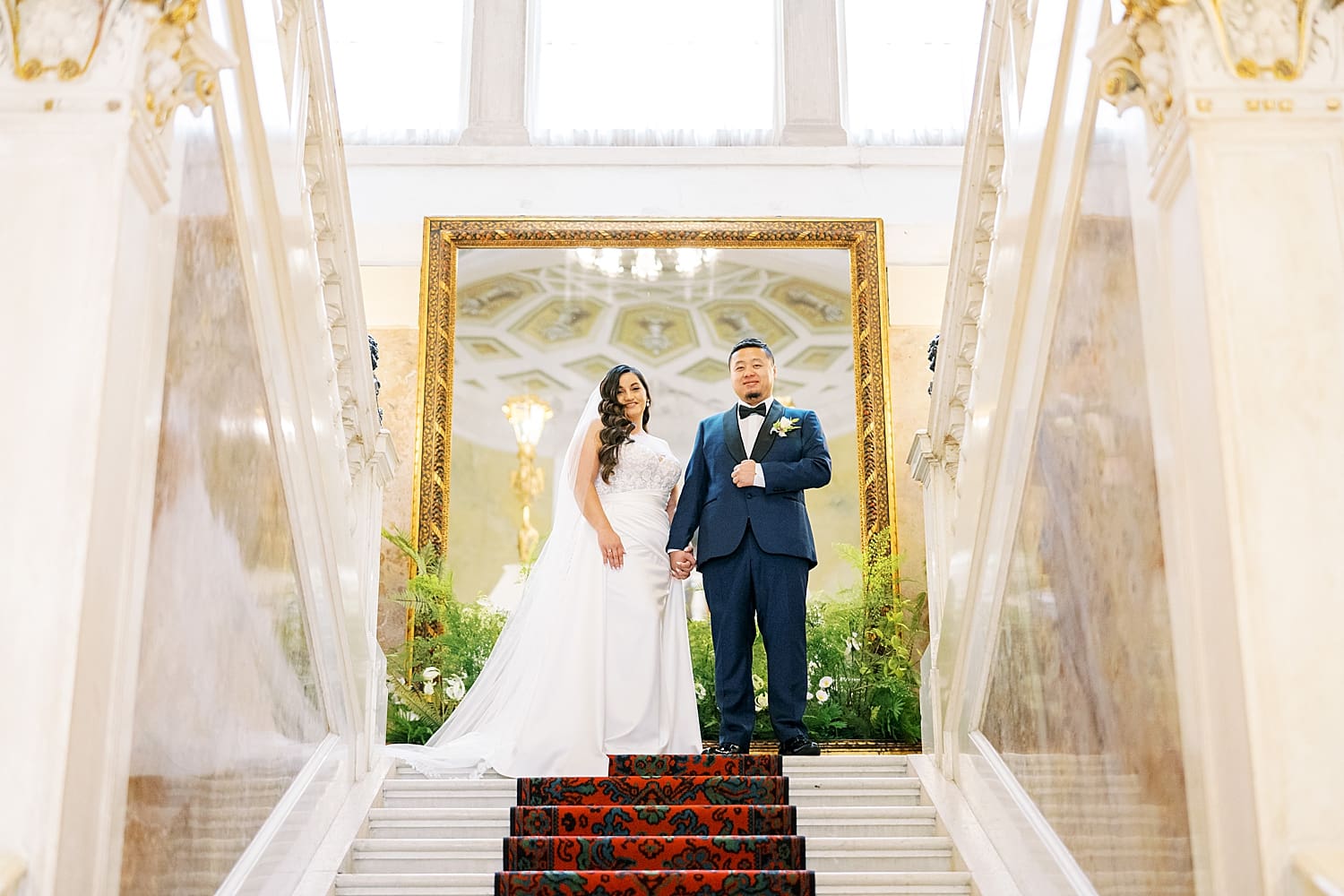 bride and groom walk down grand staircase inside Hotel Villa Serbelloni