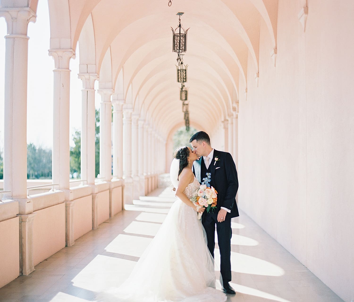 bride and groom kiss under covered loggias at The Ringling Museum of Art 